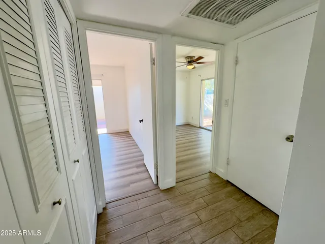 a view of a hallway with wooden floor