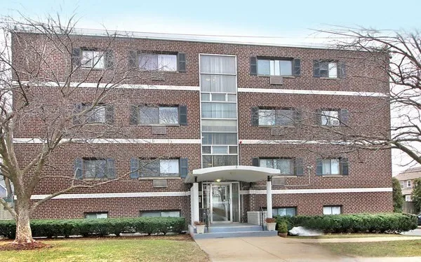 a front view of a brick building with a yard