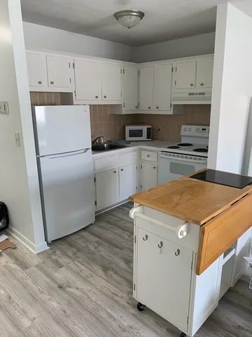 a kitchen with stainless steel appliances white cabinets and a refrigerator