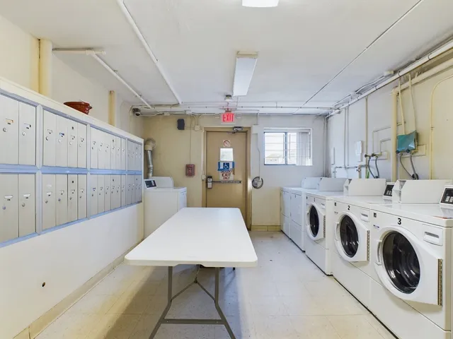 a view of a kitchen that has a microwave a stove and a dining table with wooden floor