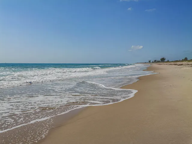 a bedroom with a bed and a lamp on dresser