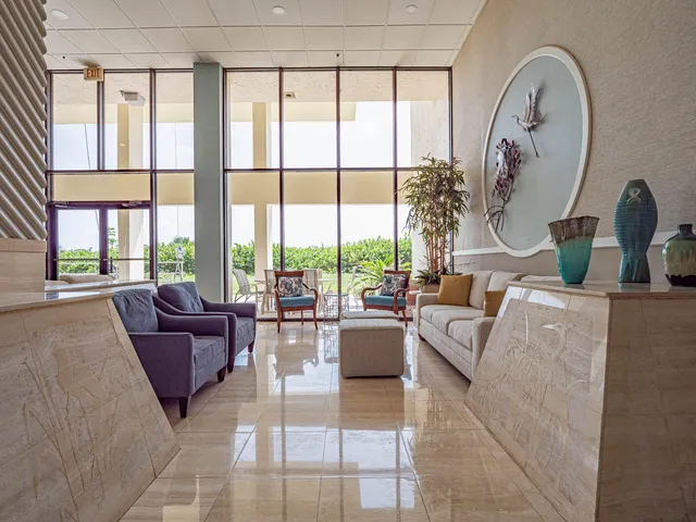 a living room with furniture a clock and a potted plant
