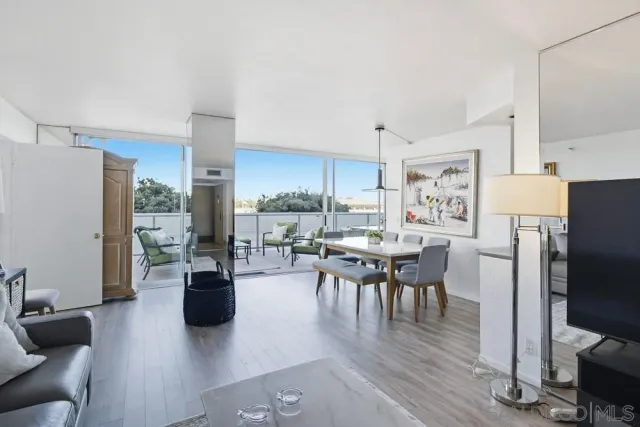 a living room with furniture a flat screen tv and kitchen view