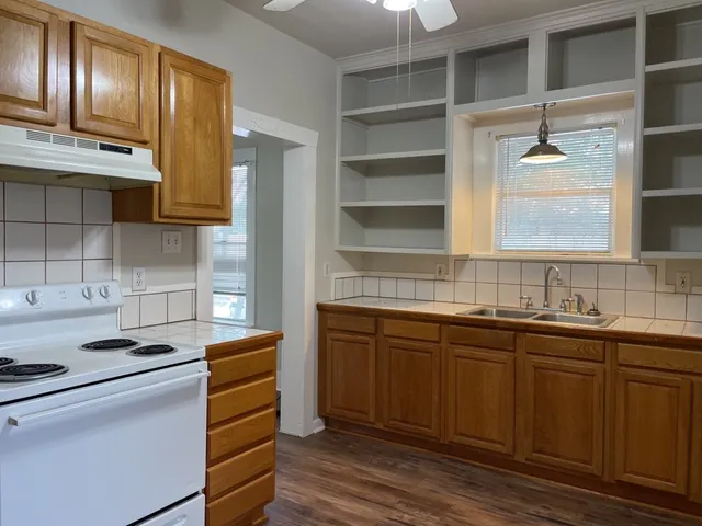 a kitchen with stainless steel appliances granite countertop a sink and wooden cabinets