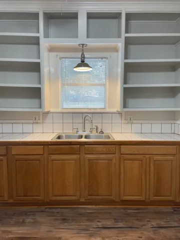 a view of a kitchen sink and wooden floor