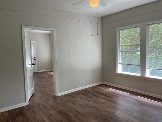 a view of a room with wooden floor and a window