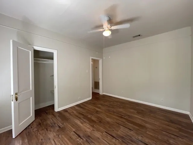 a view of an empty room with wooden floor