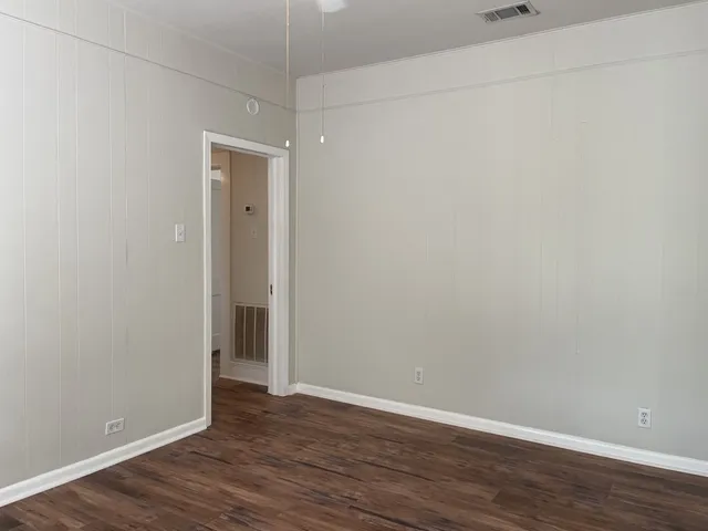 a view of an empty room with wooden floor