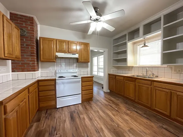 a kitchen with wooden floors and white appliances