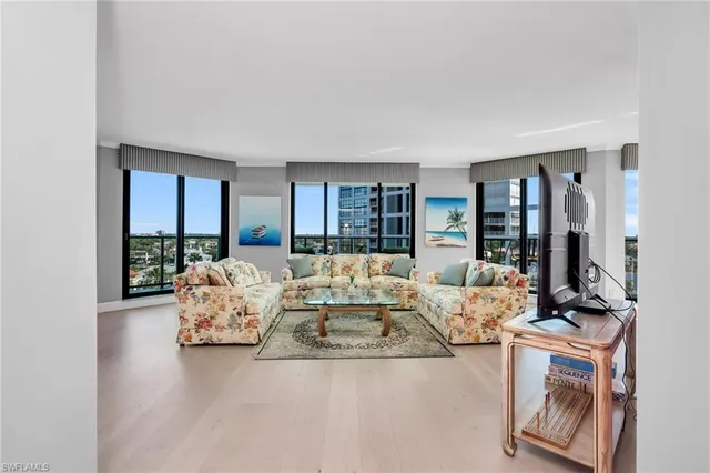 a living room with furniture a large window and a flat screen tv