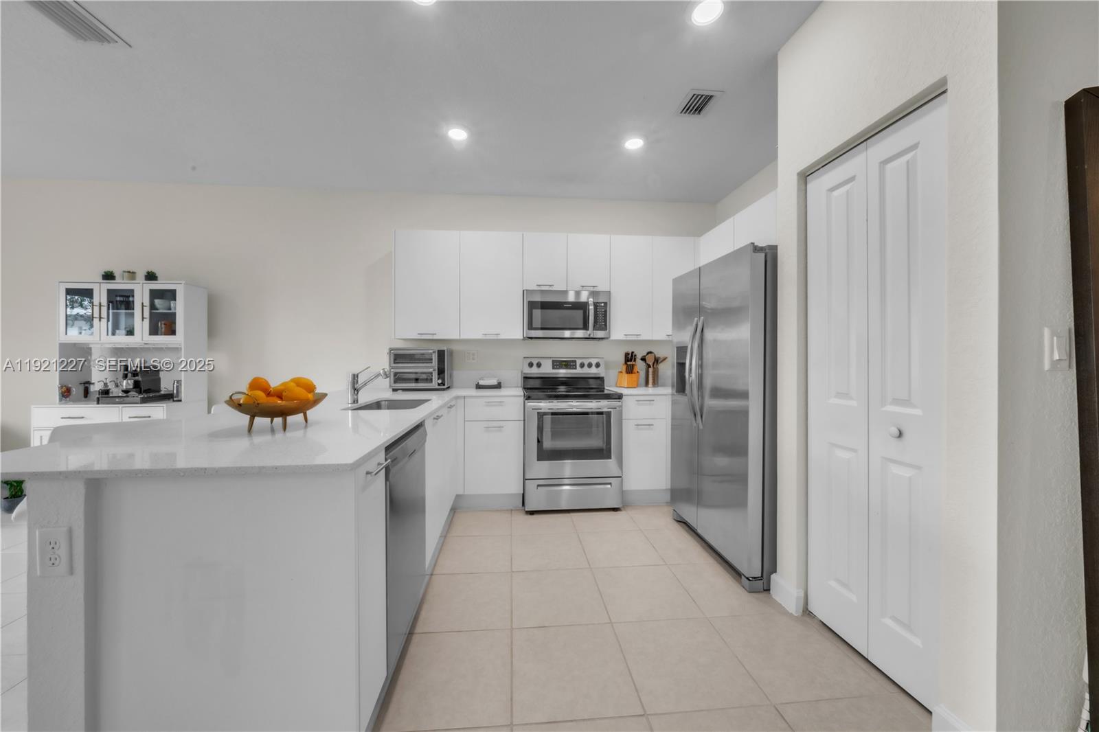 12917 Northwest 23rd Place Miami, FL 33147 - Photo 12 of 43 a kitchen with stainless steel appliances a refrigerator and a stove top oven
