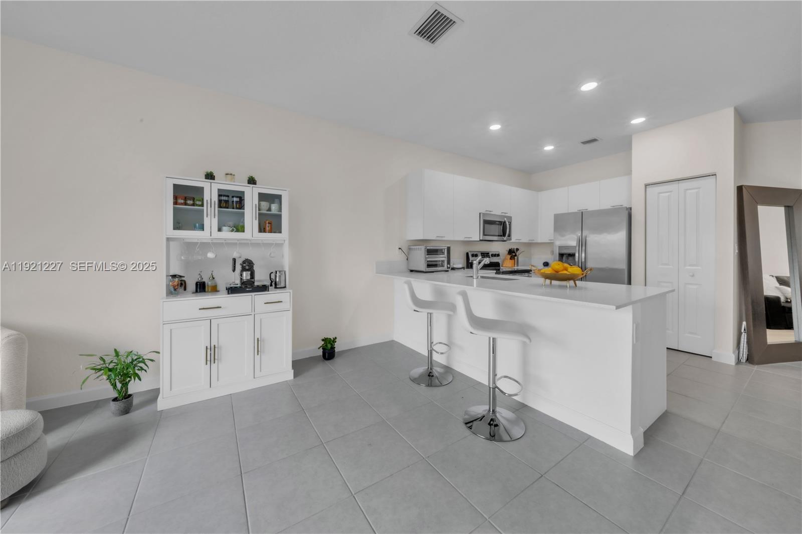 12917 Northwest 23rd Place Miami, FL 33147 - Photo 13 of 43 a kitchen with white cabinets and refrigerator