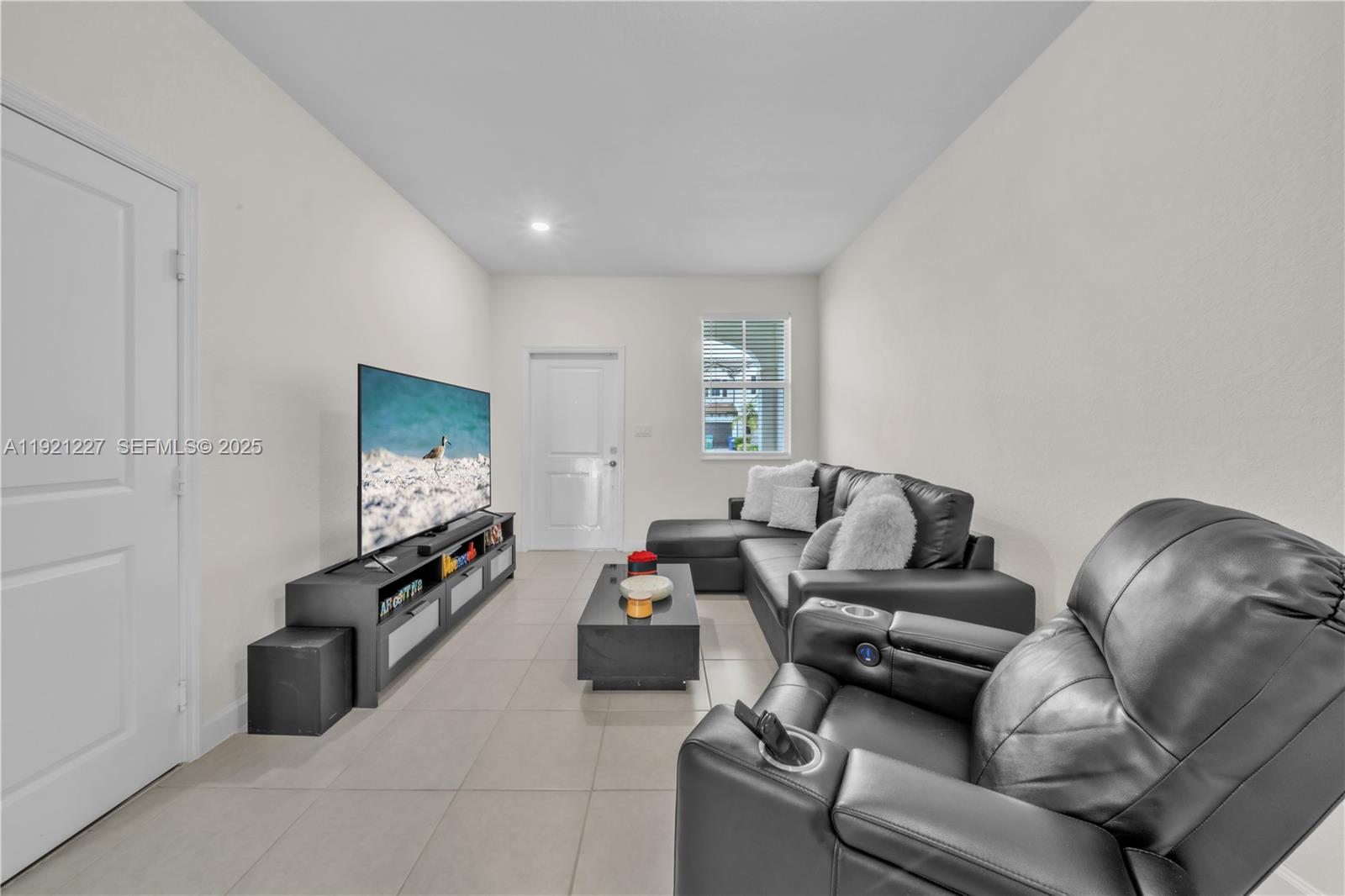 12917 Northwest 23rd Place Miami, FL 33147 - Photo 15 of 43 a living room with furniture and a flat screen tv