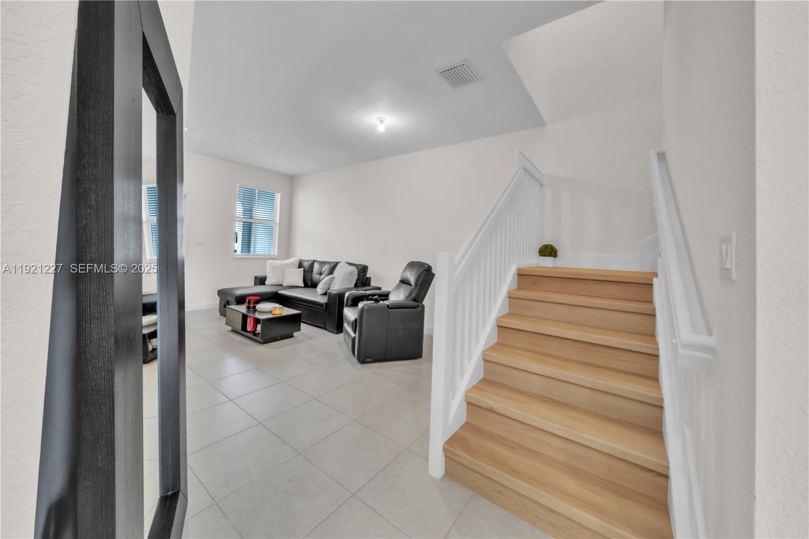 12917 Northwest 23rd Place Miami, FL 33147 - Photo 17 of 43 a view of a livingroom with a flesh screen tv and stairs