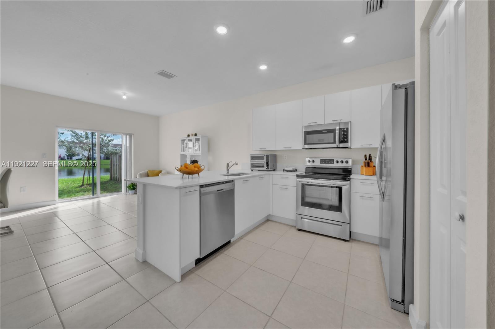 12917 Northwest 23rd Place Miami, FL 33147 - Photo 8 of 43 a kitchen with stainless steel appliances a stove a sink and a refrigerator