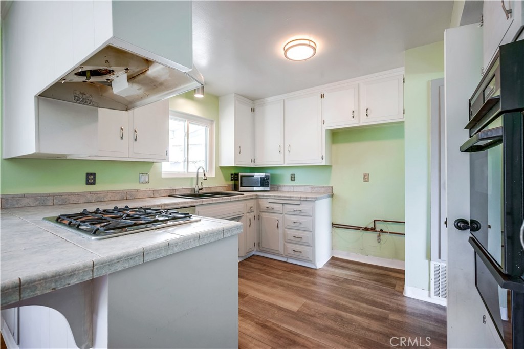 6473 Capistrano Way Riverside, CA 92504 - Photo 11 of 28 a kitchen with a stove a sink and a refrigerator