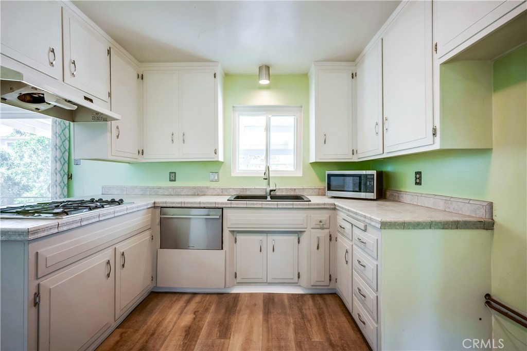6473 Capistrano Way Riverside, CA 92504 - Photo 12 of 28 a kitchen with stainless steel appliances granite countertop a stove a sink and a microwave