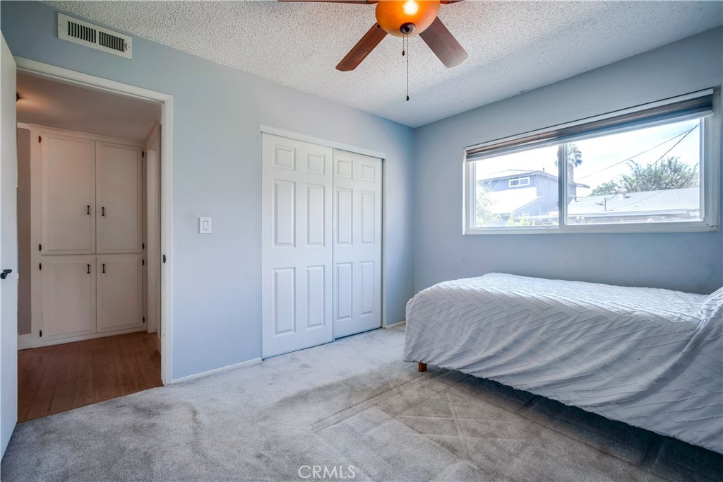6473 Capistrano Way Riverside, CA 92504 - Photo 17 of 28 a bedroom with a bed and a chandelier