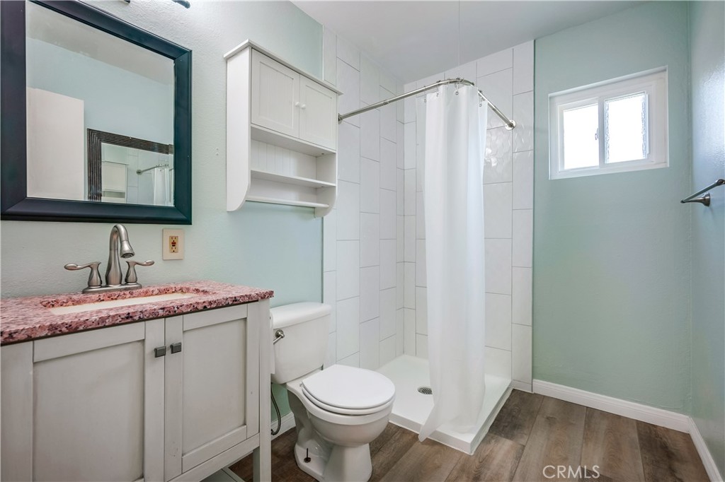 6473 Capistrano Way Riverside, CA 92504 - Photo 20 of 28 a bathroom with a granite countertop sink toilet and mirror