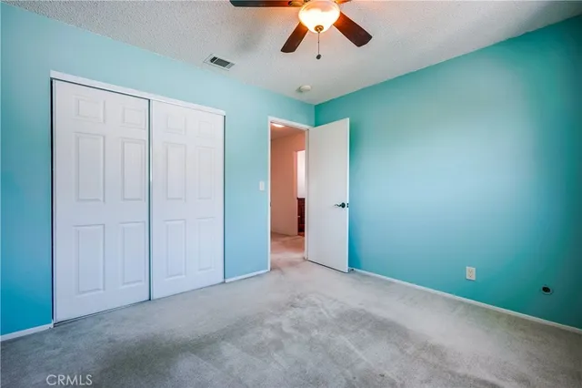 an empty room with a ceiling fan and a window