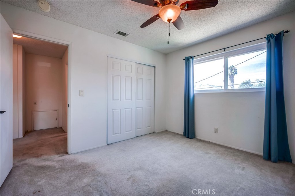 6473 Capistrano Way Riverside, CA 92504 - Photo 25 of 28 an empty room with a chandelier fan and windows