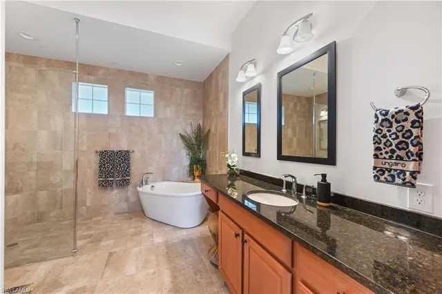 a spacious bathroom with a granite countertop sink and a mirror
