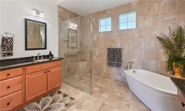 a spacious bathroom with a tub sink and mirror