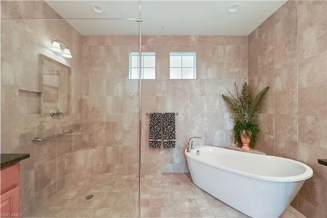 a white bath tub sitting in a bathroom and shower