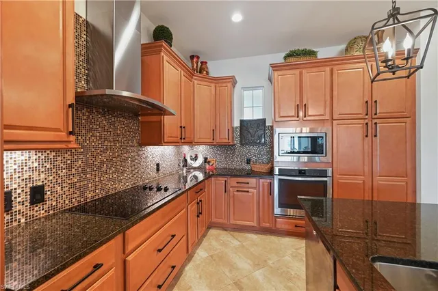 a kitchen with stainless steel appliances granite countertop a sink stove and cabinets