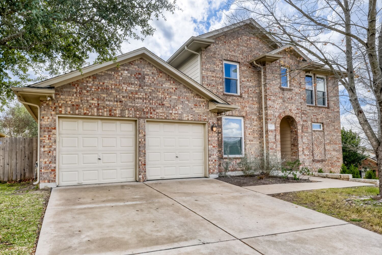 Traditional home with concrete driveway, a garage, and brick siding