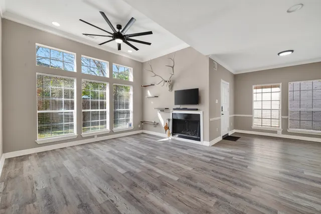 a view of empty room with wooden floor and fireplace