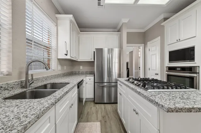 a kitchen with stainless steel appliances granite countertop a sink stove and refrigerator