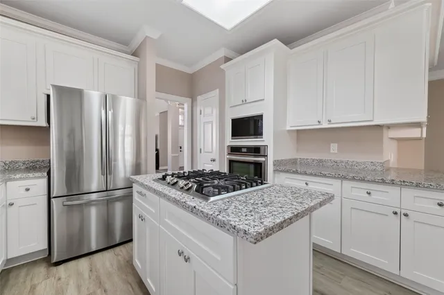 a kitchen with granite countertop a refrigerator stove and sink