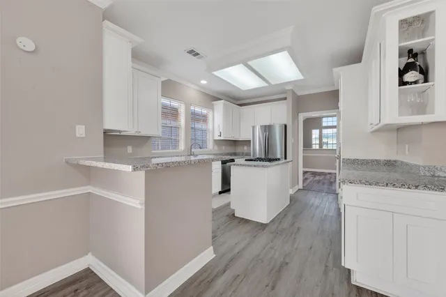 a kitchen with white cabinets and appliances