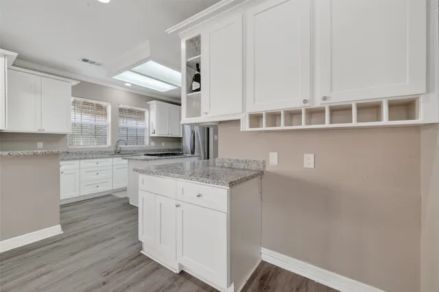 a kitchen with stainless steel appliances granite countertop a stove and white cabinets