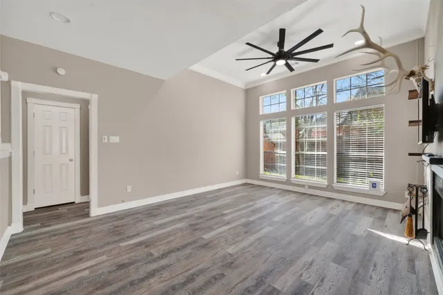 a view of a livingroom with wooden floor and a ceiling fan