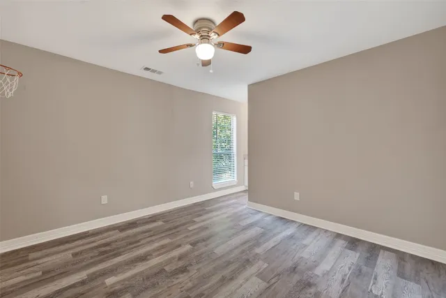 an empty room with closet and a ceiling fan