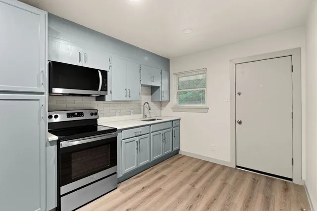 a kitchen with a sink stove and microwave
