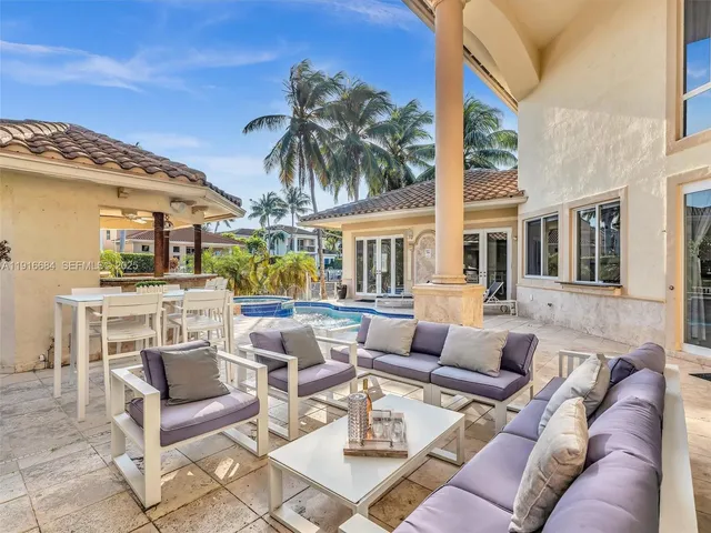 a living room with furniture a fireplace and potted plants
