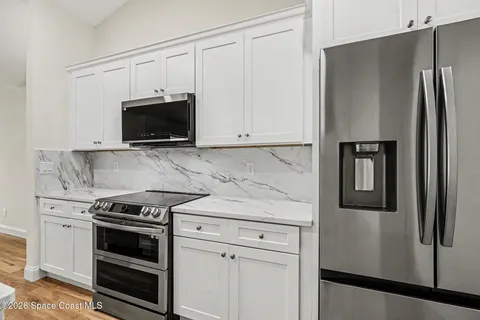 a kitchen with white cabinets and stainless steel appliances
