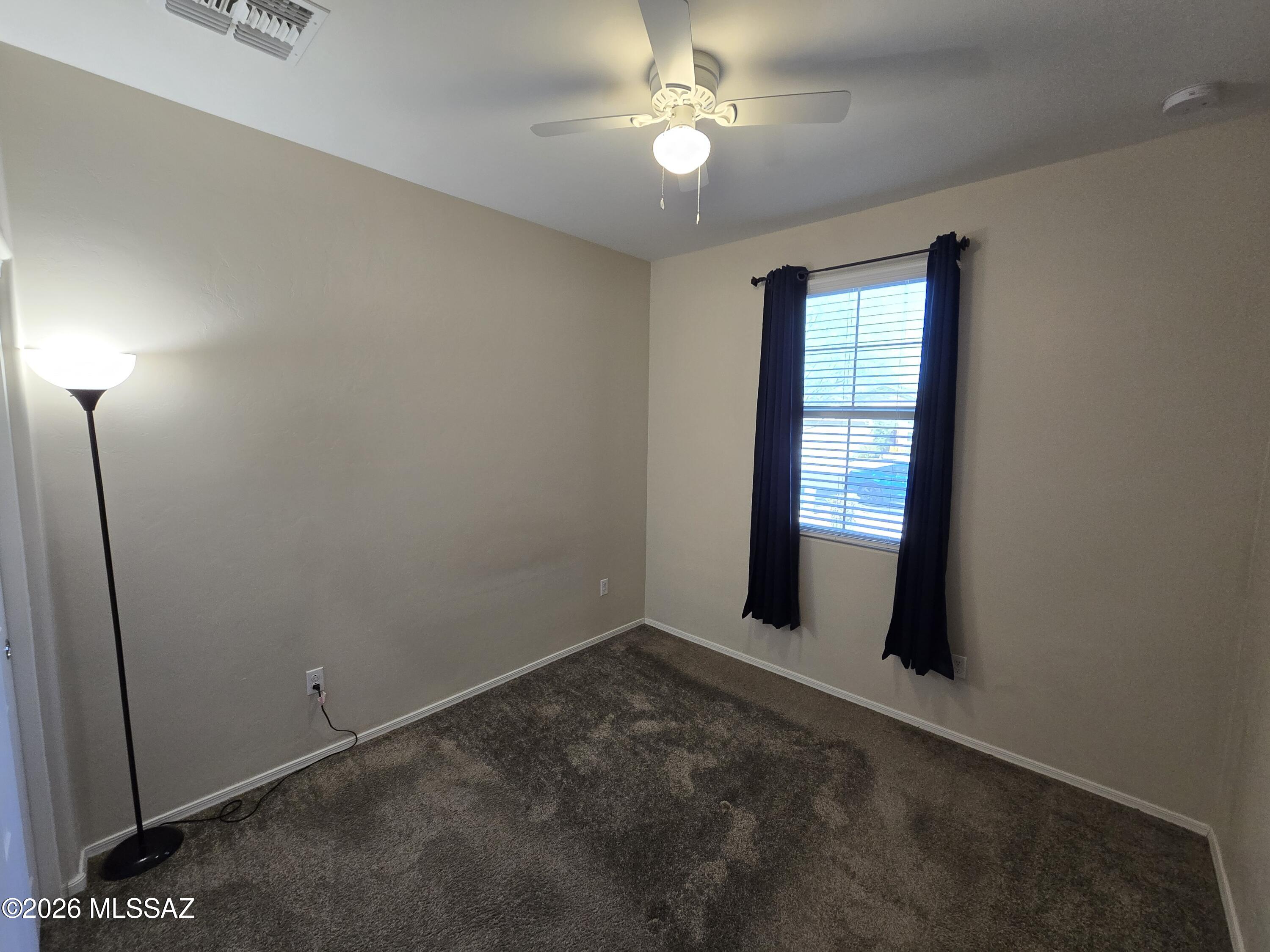 6151 South Antrim Loop Tucson, AZ 85706 - Photo 9 of 13 an empty room with windows and fan