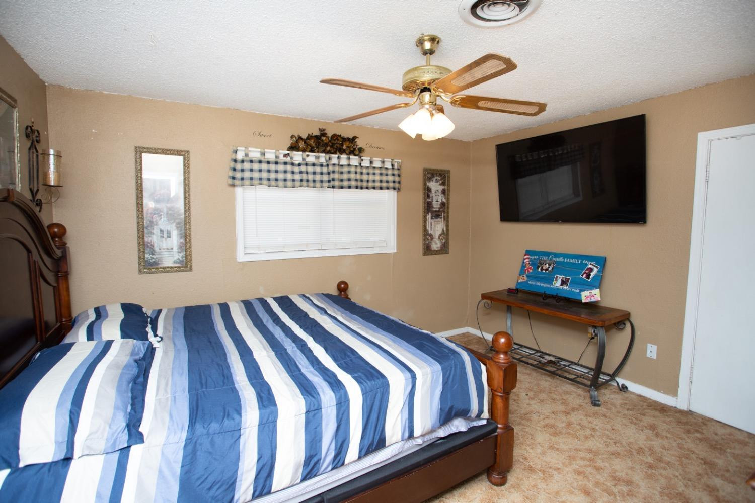 306 Terry Avenue Wellman, TX 79316 - Photo 13 of 32 a bedroom with a bed a flat screen tv and a window