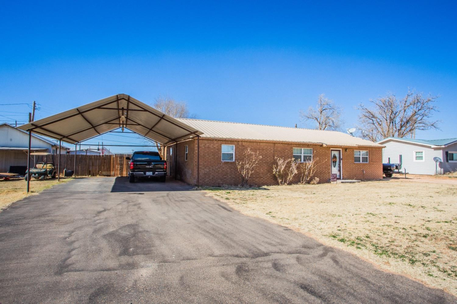 306 Terry Avenue Wellman, TX 79316 - Photo 2 of 32 a wooden bench sitting in front of a building