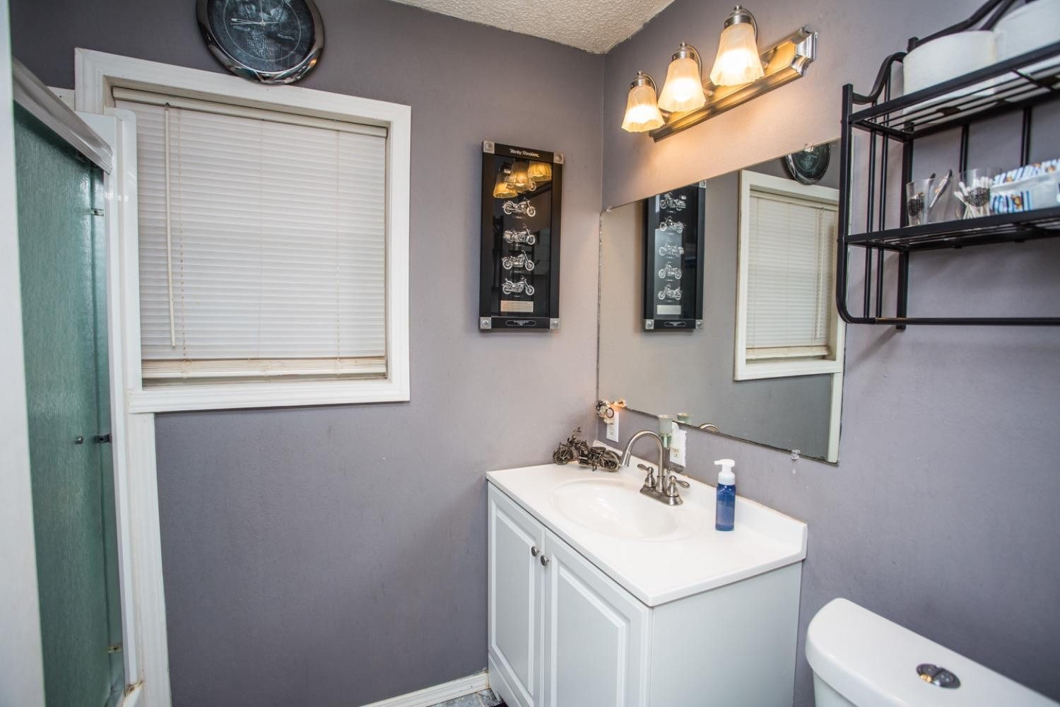 306 Terry Avenue Wellman, TX 79316 - Photo 22 of 32 a bathroom with a toilet sink and mirror