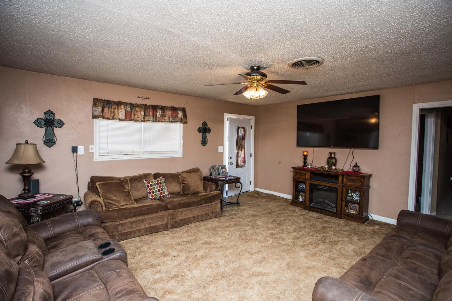 306 Terry Avenue Wellman, TX 79316 - Photo 5 of 32 a living room with furniture and a flat screen tv