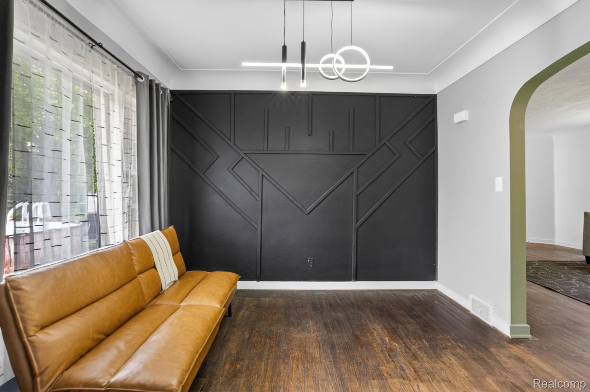 1209 Beatrice Street Flushing, MI 48433 - Photo 12 of 39 Sitting room featuring arched walkways, dark wood-style flooring, an accent wall, and a decorative wall