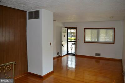 8106 Ridgely Oak Road Baltimore, MD 21234 - Photo 13 of 21 a view of an empty room with window and wooden floor