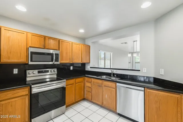 a kitchen with stainless steel appliances a refrigerator sink and microwave