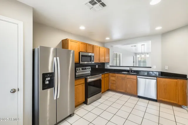 a kitchen with granite countertop a sink stainless steel appliances and cabinets