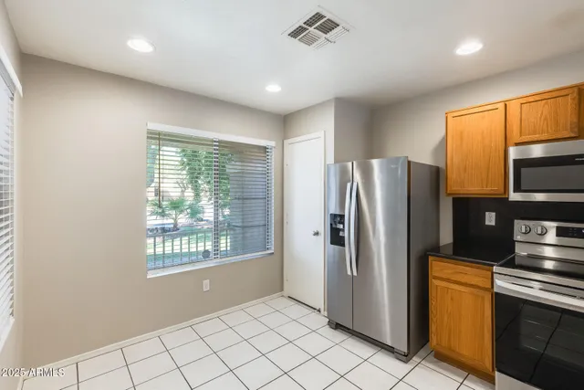 a kitchen with stainless steel appliances granite countertop a refrigerator and a sink
